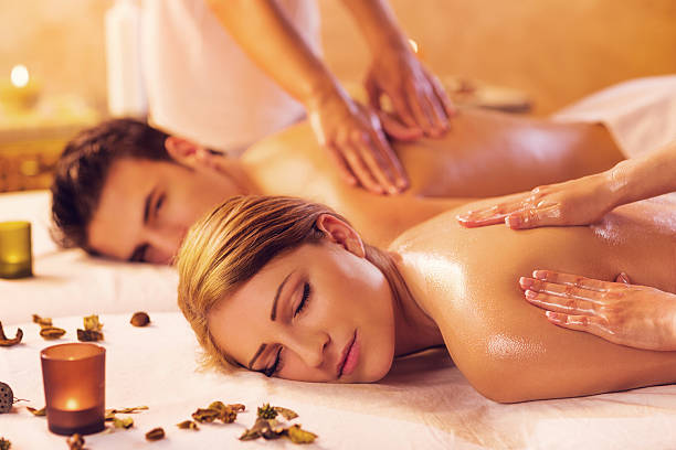 Couple receiving back massage at the spa. Focus is on foreground.